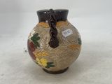 a small vase that has a handle on it