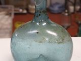une bouteille en verre bleue posée sur une table dans un atelier