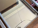 a bird that is sitting on the floor in front of a refrigerator