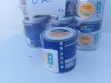 many cans of paint on a table with a price tag