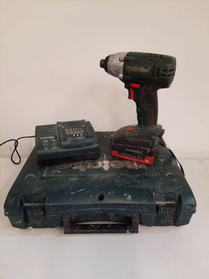 a drill and a battery in a case on a table