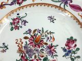 a plate with flowers and birds on it on a table