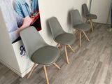 four chairs lined up against a wall with a picture of a man