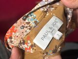 someone is holding a small purse with a label on it