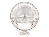 un plat ancien en argent avec un couvercle en verre, posé sur un socle
