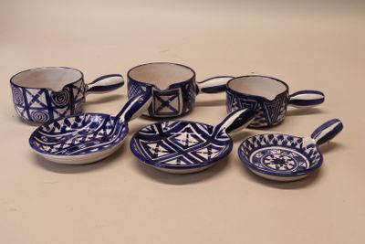 plusieurs tasses et soucoupes bleues et blanches posées sur une table