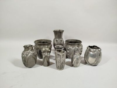 several silver vases sitting on a white surface with a white background
