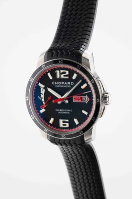 a close up of a black watch with a red second hand