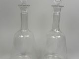 two clear glass vases sitting on top of a white table