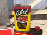 a can of car polish next to a can of auto oil