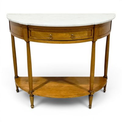 une photo d'une table au plateau en marbre, avec une étagère en dessous