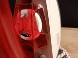 a red and white iron sitting on a wooden table
