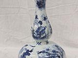 a blue and white vase sitting on a white surface