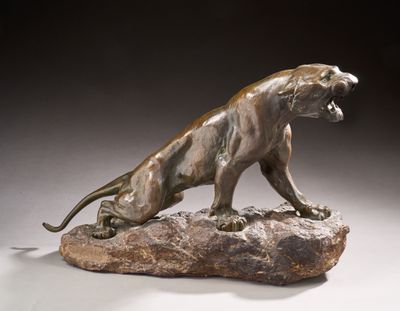 statue of a lion on a rock on a gray background