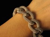 someone is wearing a silver bracelet with a knot on it