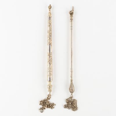 two silver spoons and a spoon with a handle on a white surface