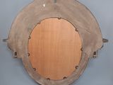a picture of a wooden circular mirror on a wall