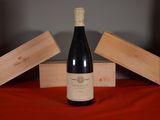 a bottle of wine sitting on a table next to two wooden boxes
