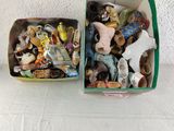two boxes filled with different types of figurines on a table