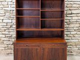 a mid century walnut bookcase with two doors and shelves