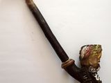 une pipe sur laquelle repose une feuille, posée sur une table
