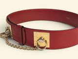 a red belt with a gold buckle and a chain