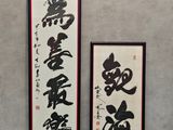 deux calligraphies chinoises accrochées l'une à côté de l'autre sur un mur