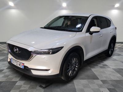 La Mazda CX-5 blanche est garée sur un sol à damier.