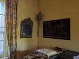 a bed in a room with a window and a painting on the wall