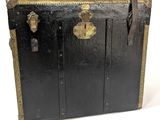 a black trunk with brass hardware on it