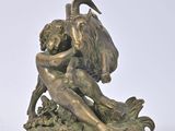 bronze statue of a woman and a goat on a rock