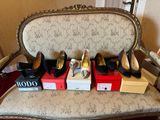 several pairs of women ' s shoes sitting on top of boxes on a chair