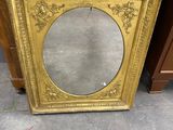 an antique gold frame with a mirror on top of it