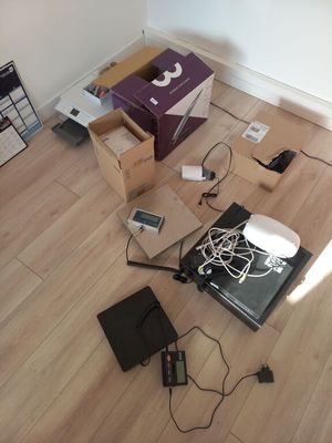 un tas d'appareils électroniques par terre, à côté d'une boîte