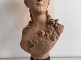a bust of a woman sitting on a marble table