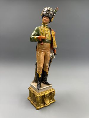 statue d'un soldat muni d'un fusil et portant un chapeau, posée sur un socle