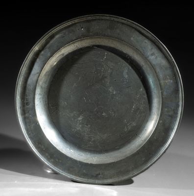 a silver plate sitting on a table with a black background