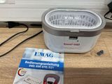 une boîte de nourriture posée par terre à côté d'une autre boîte de nourriture