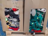 two cardboard boxes with clothes in them on a pallet