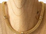 a close up of a mannequin wearing a gold chain necklace