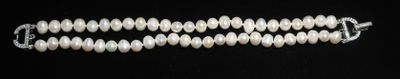 un gros plan sur un collier de perles blanches sur fond noir