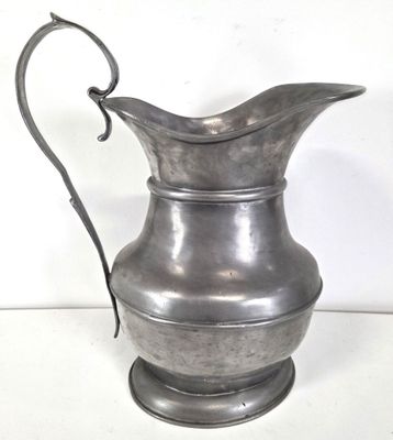 a silver pitcher that is sitting on a table