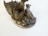 a statue of a bird and a bird nest on a plate