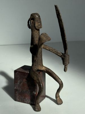 statue d'un homme tenant un couteau et une épée posés sur un billot