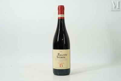 the bottle of red wine is sitting on a white surface