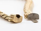 an image of a gold bracelet with a stone in the middle of it