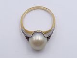 an image of a pearl and diamond ring on a white surface