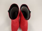 une paire de chaussures rouges posées sur une surface blanche, avec un fond blanc