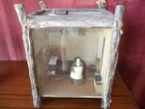 une petite boîte en bois contenant des toilettes et un distributeur de papier toilette
