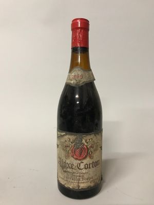 une vieille bouteille de vin posée sur une table blanche
